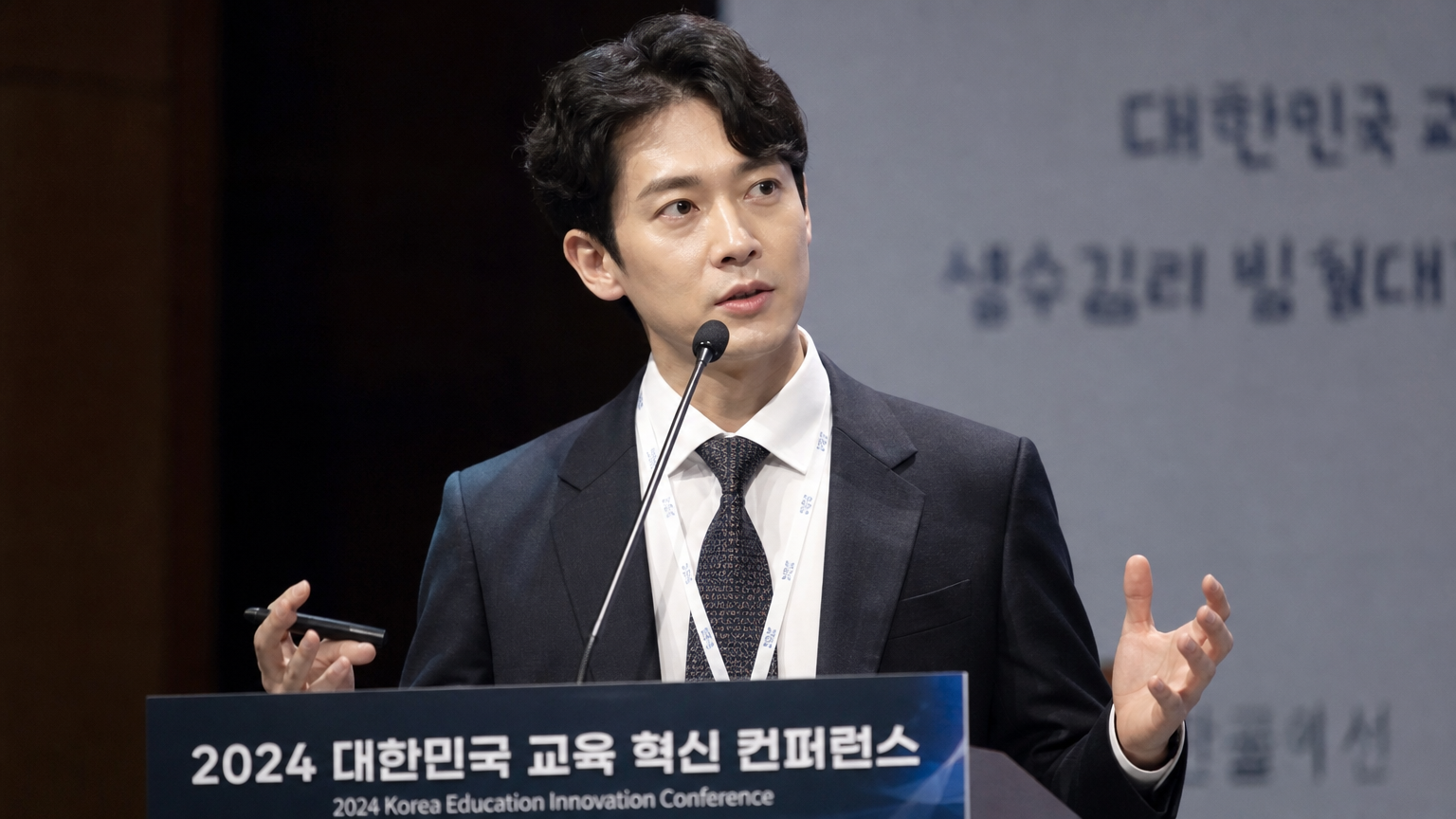 교육 회의에서 강력한 연설을 하는 정장을 입은 카리스마 넘치는 한국 남성
