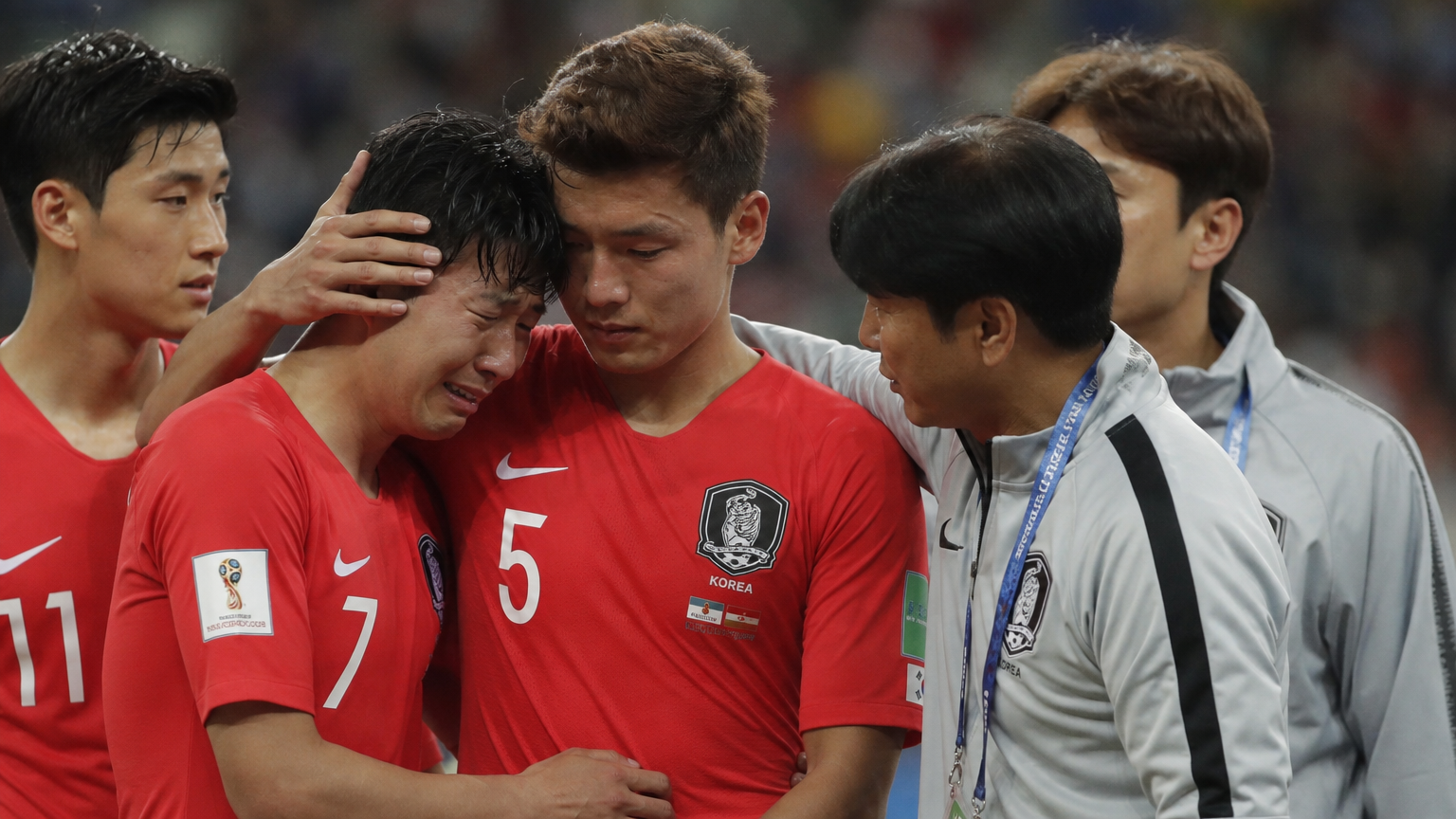 어려운 경기 순간 후 팀 동료와 코치에게 위로받는 한국 축구 선수