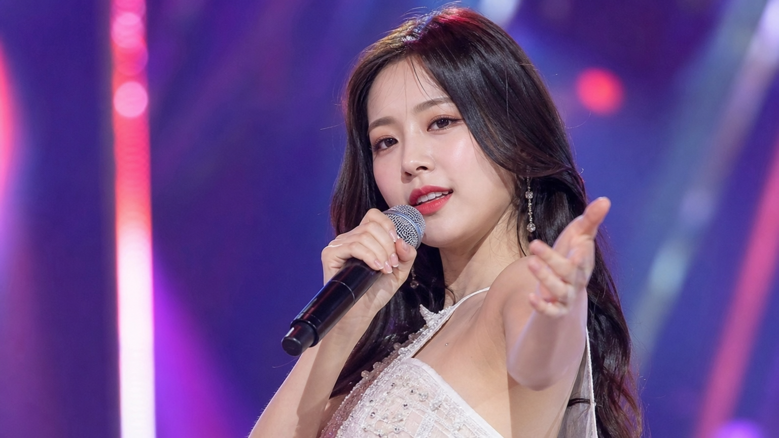 무대에서 노래하는 매력적인 여성 가수의 생동감 넘치는 모습