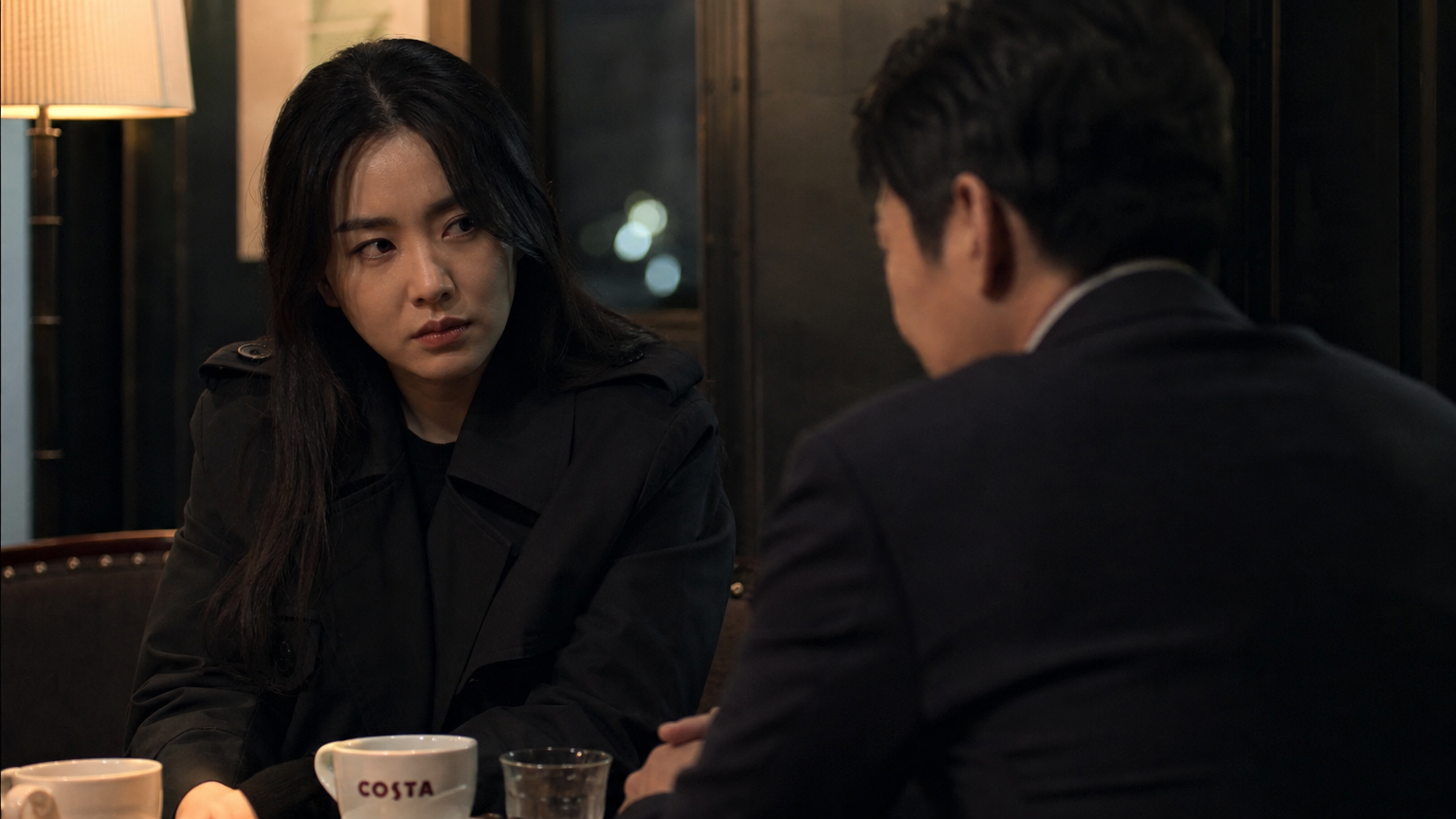 어두운 카페 구석에서 은밀하게 만나는 남녀의 모습