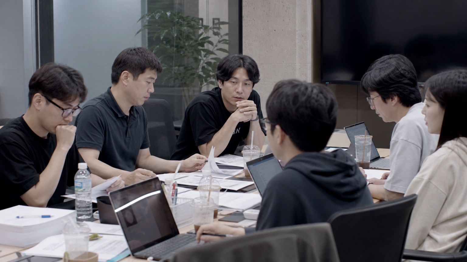 현대식 사무실에서 심각한 회의를 진행하는 제작진 모습
