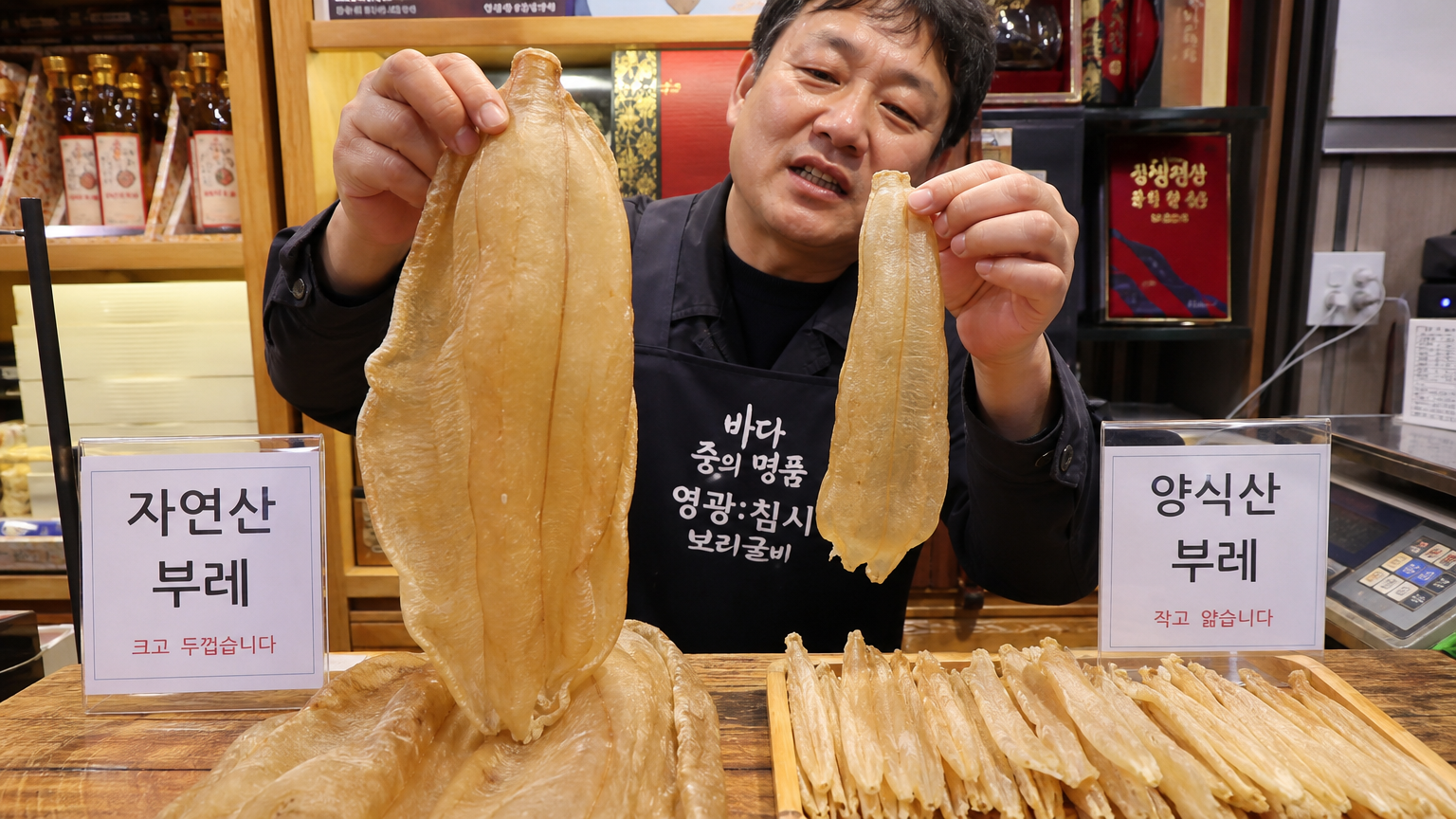나무 조리대 위에 자연산과 양식 민어의 부레를 비교해 놓은 모습