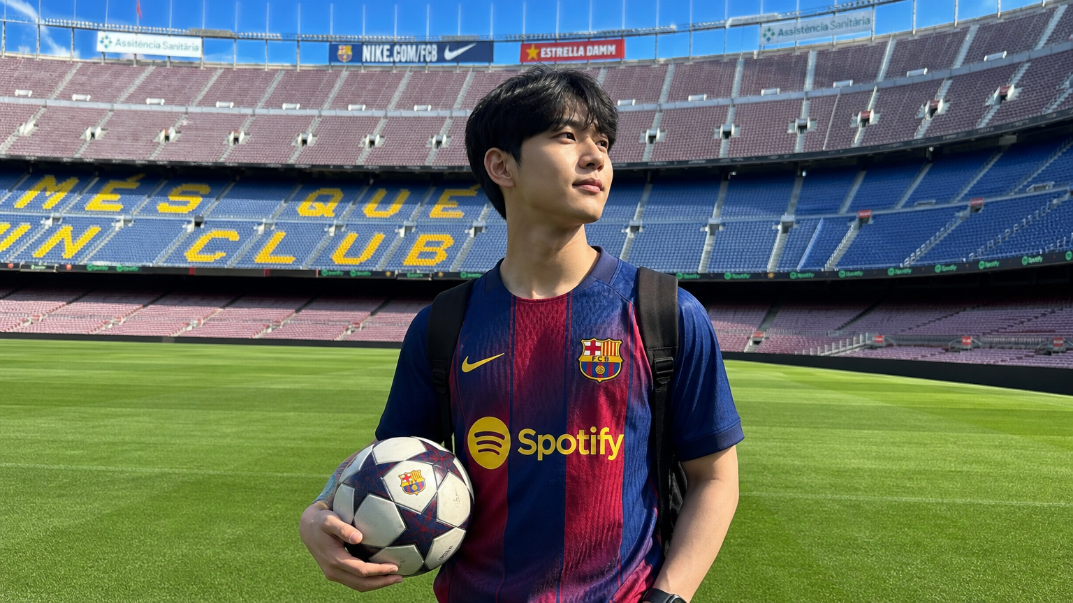 젊은 성인이 축구공을 들고 바르셀로나의 활기찬 축구장에서 포부와 집중력을 보여주는 모습