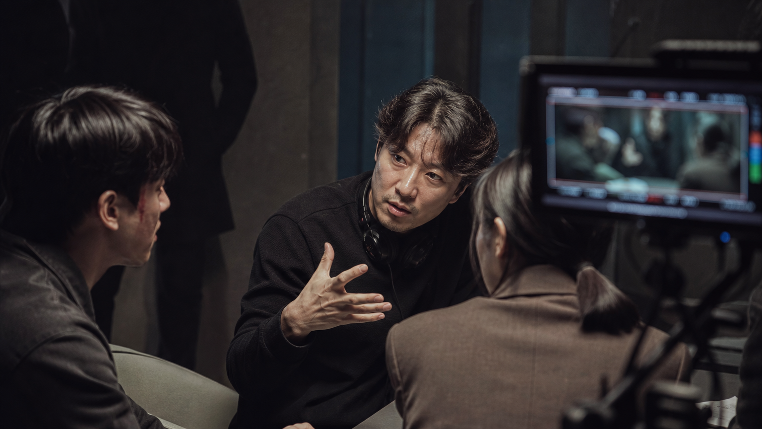 이현우 감독이 배우들과 함께 긴장감 넘치는 장면을 촬영하는 모습