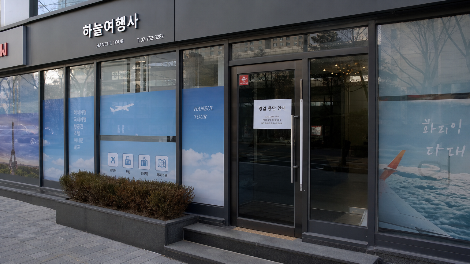 서울의 한 현대적인 닫힌 여행사 사무실 외관과 중단 안내문