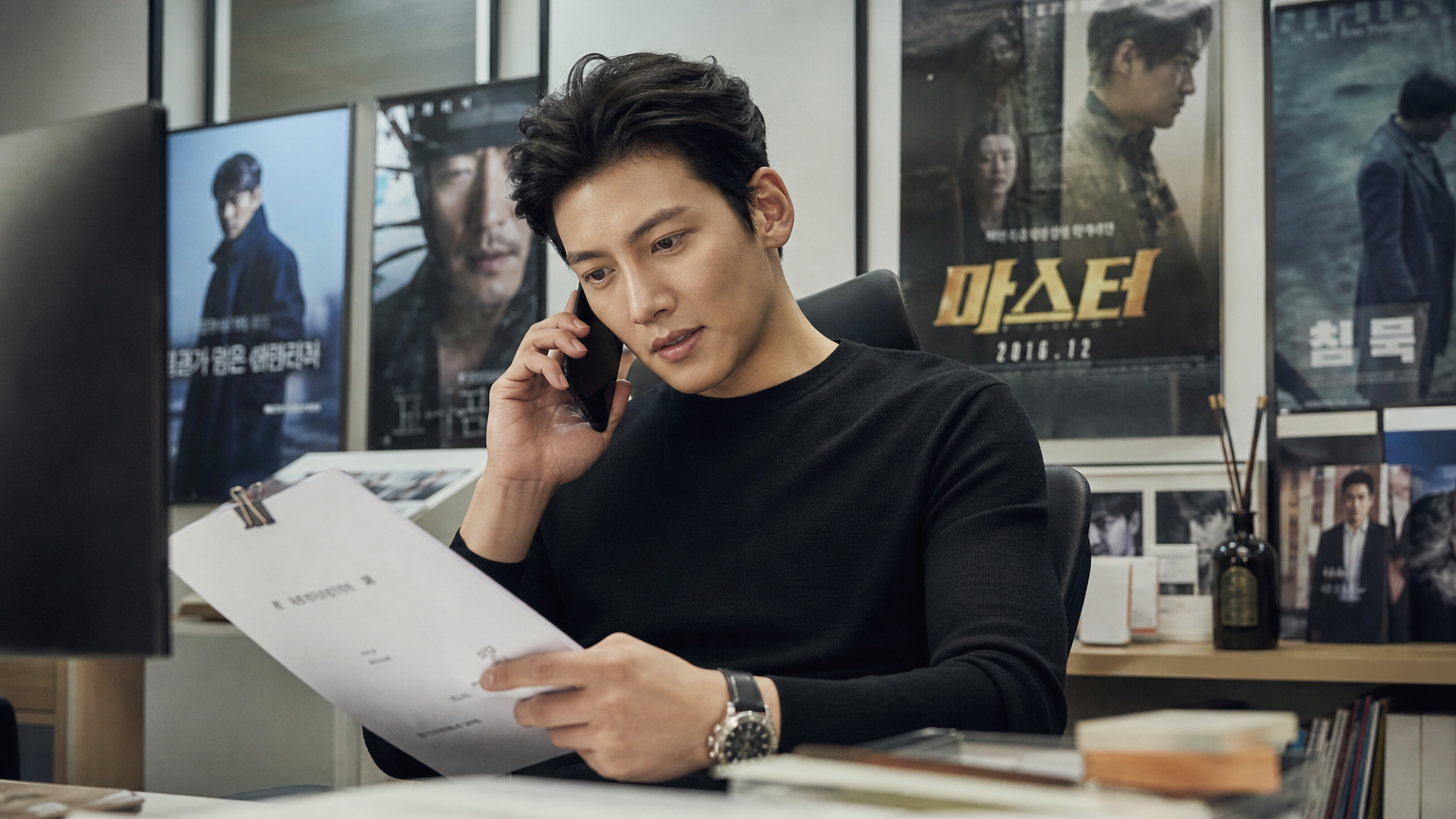 현대적 사무실에서 대본을 검토하며 전화 통화를 하고 있는 자신감 넘치는 배우