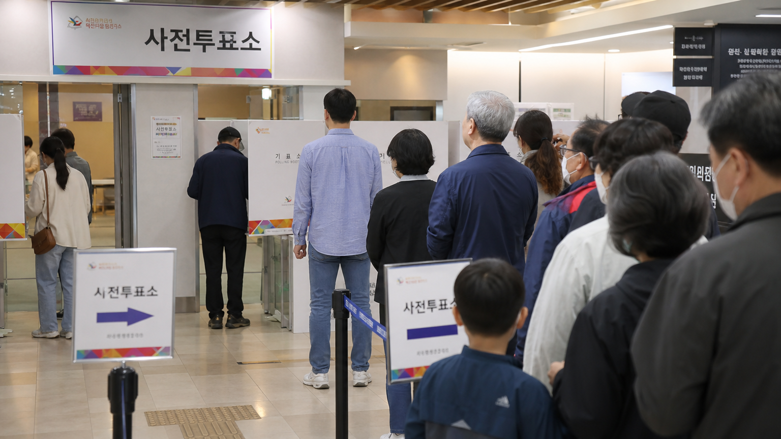 다양한 연령층의 사람들이 줄을 서서 투표하는 바쁜 한국 투표소 내부