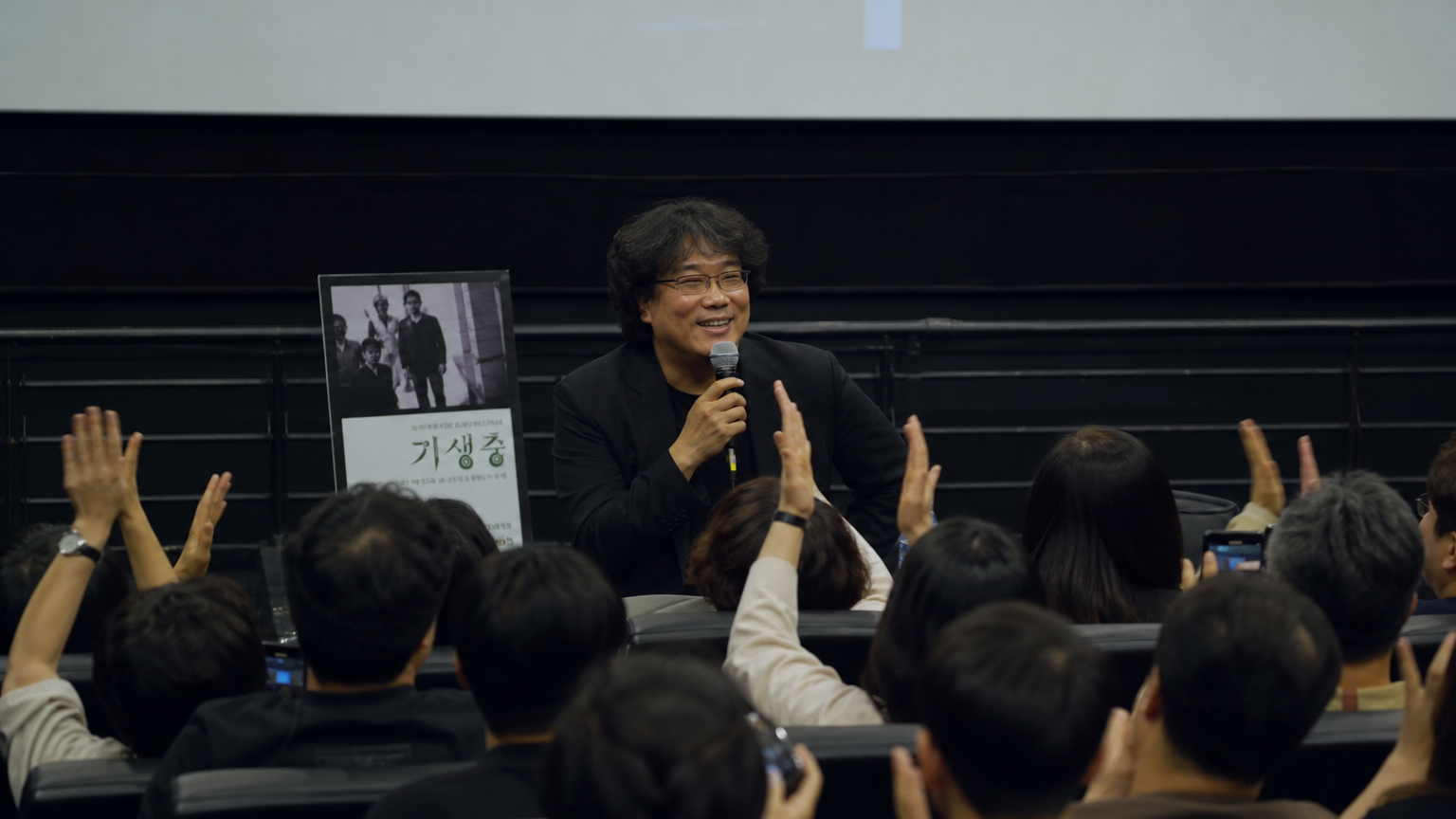 극장에서 상영 후 관객과 대화를 나누는 영화 감독의 모습