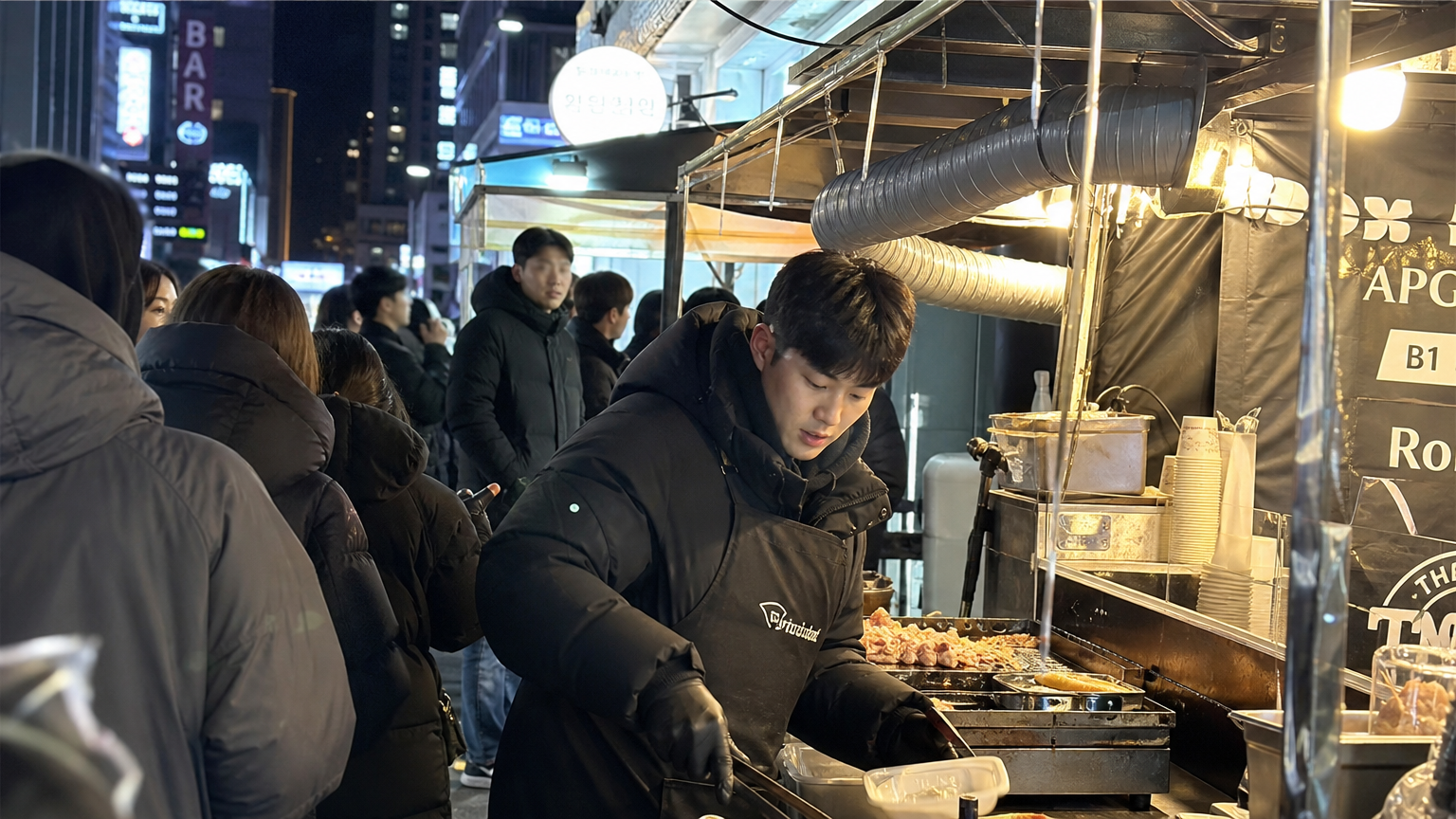 밤에도 분주한 압구정 거리 음식 노점과 열심히 일하는 젊은 남성