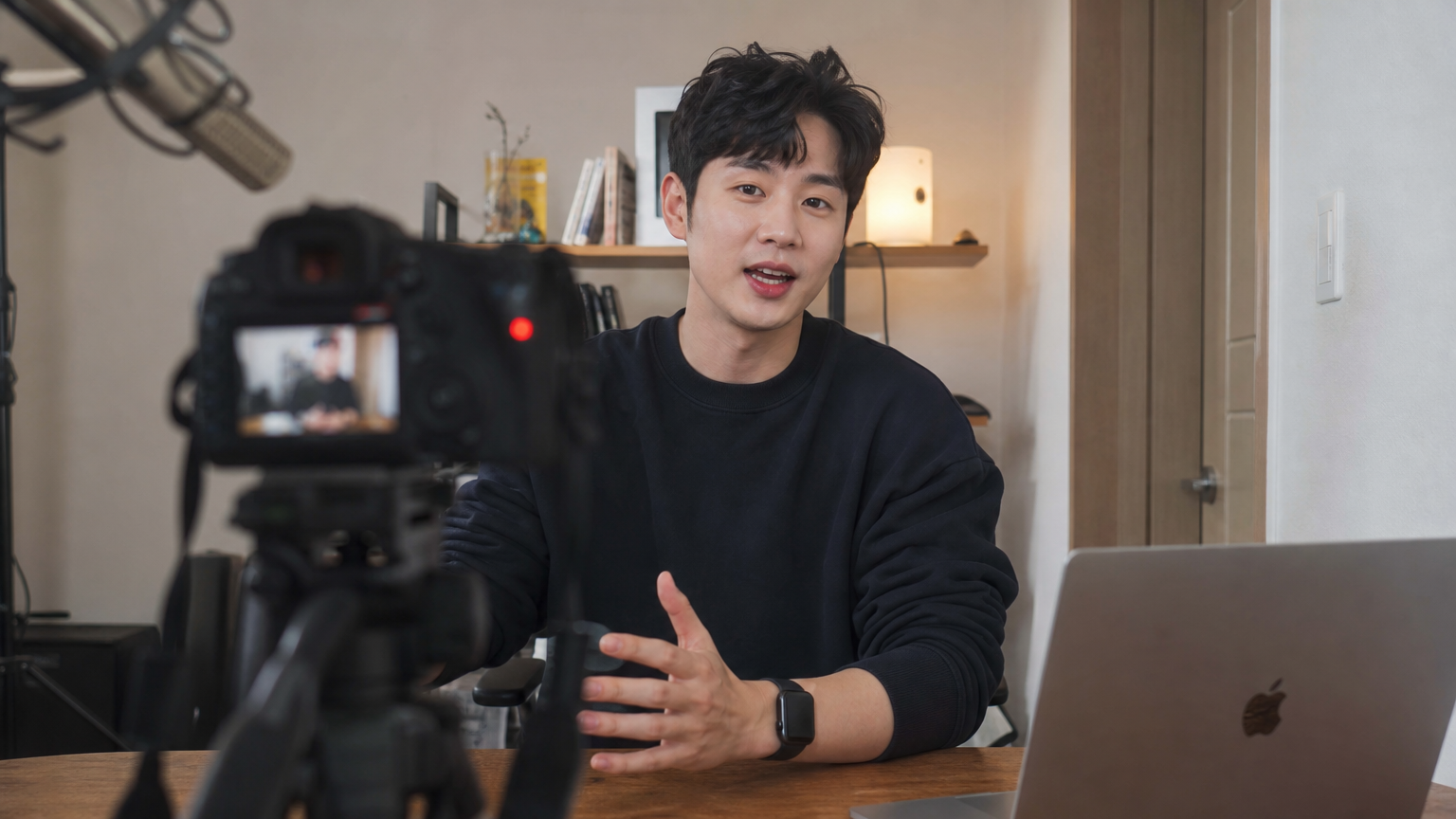 집에서 카메라와 노트북을 사용해 브이로그를 녹화 중인 남성의 자연스러운 모습