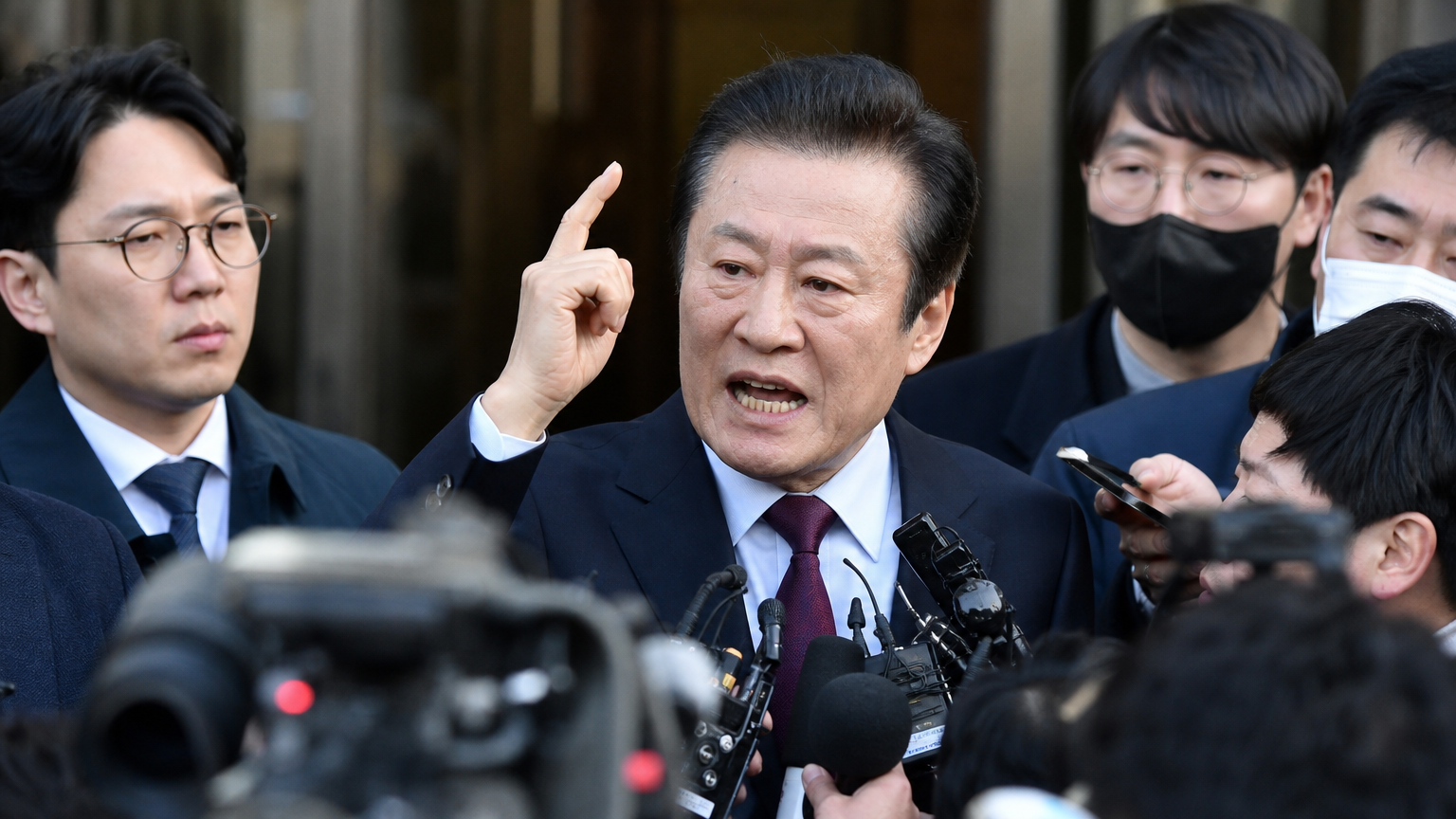 기자회견장에서 열정적으로 발언하는 전직 정치인의 모습