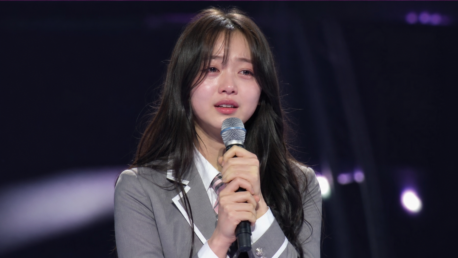 무대 위에서 눈물을 흘리는 십대 소녀의 모습