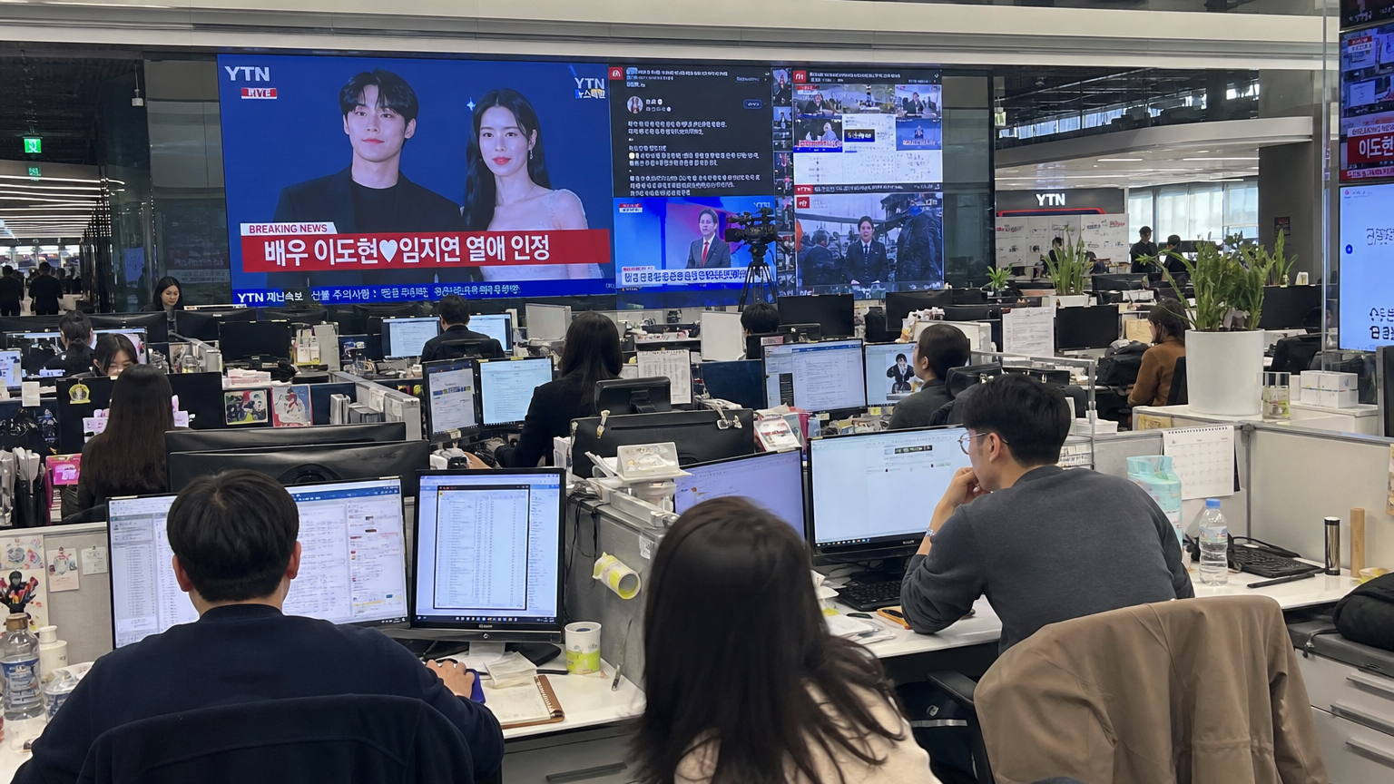 현대적인 한국 뉴스룸에서 기자들이 컴퓨터로 작업하는 모습