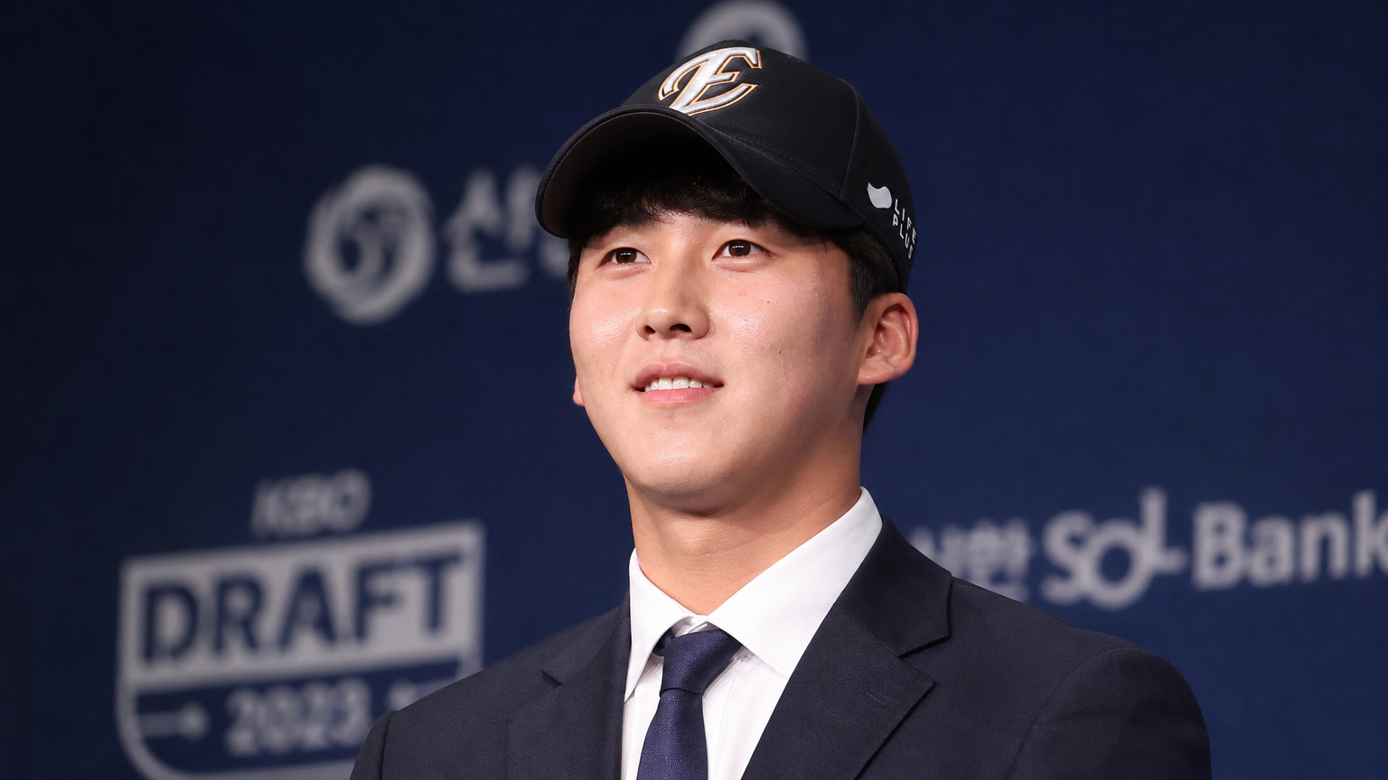 야구 드래프트 행사장에서 기대감에 찬 젊은 선수의 모습
