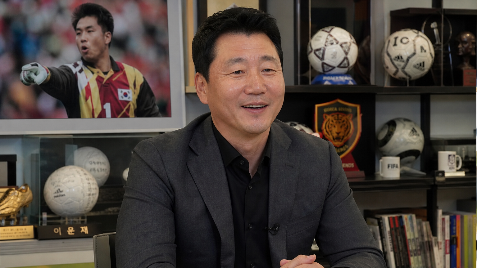 스포츠 기념품으로 둘러싸인 현대적인 환경 속에서 프로페셔널한 모습의 축구 레전드