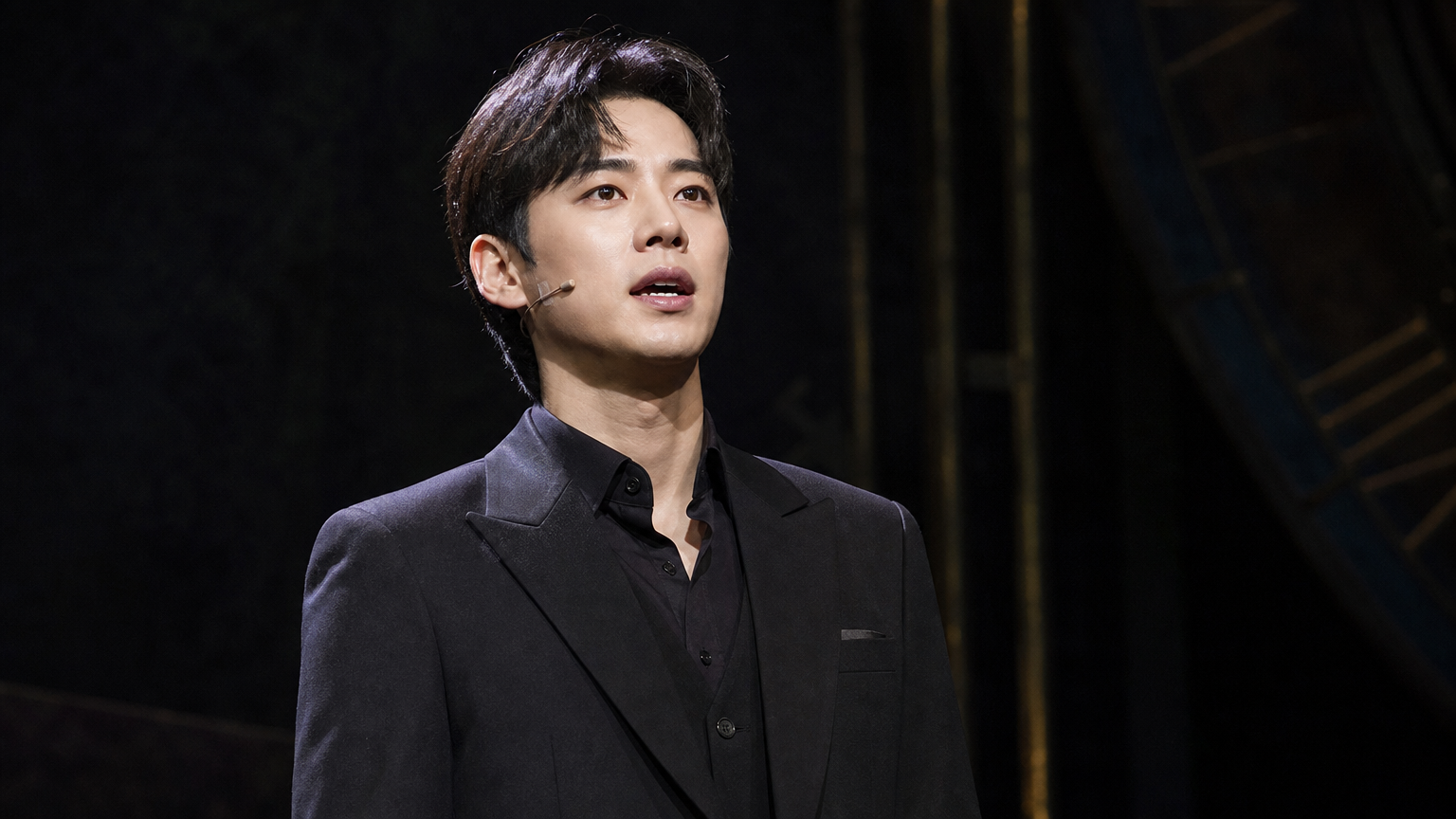뮤지컬 무대에서 카리스마 넘치고 자신감 있는 모습으로 공연하는 남자 배우