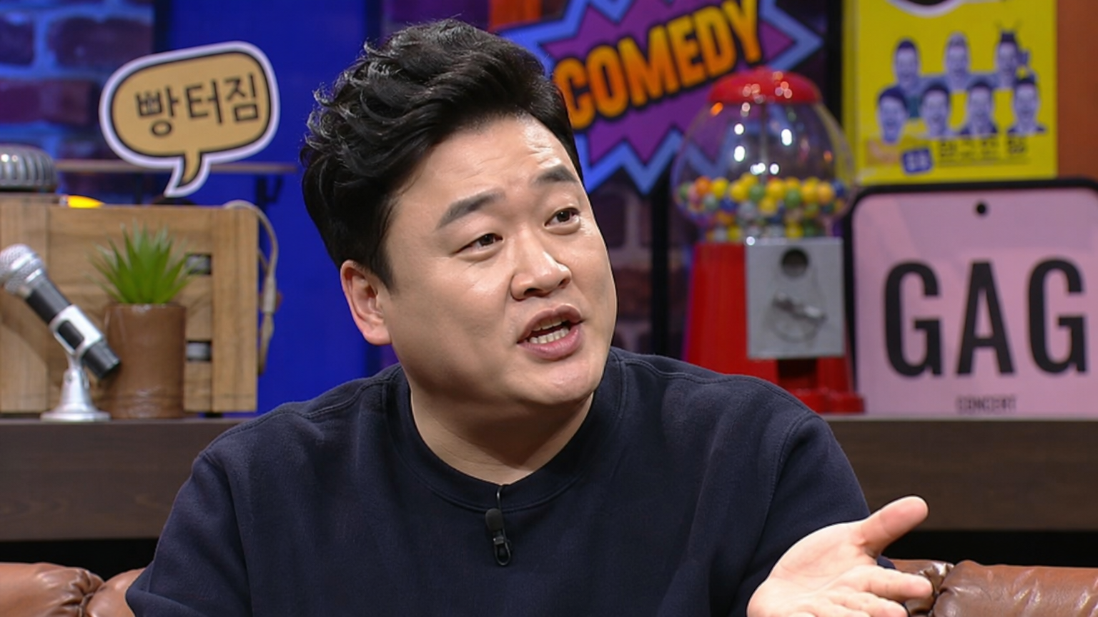 스튜디오에서 다양한 소품들과 함께 있는 현대 개그맨의 모습