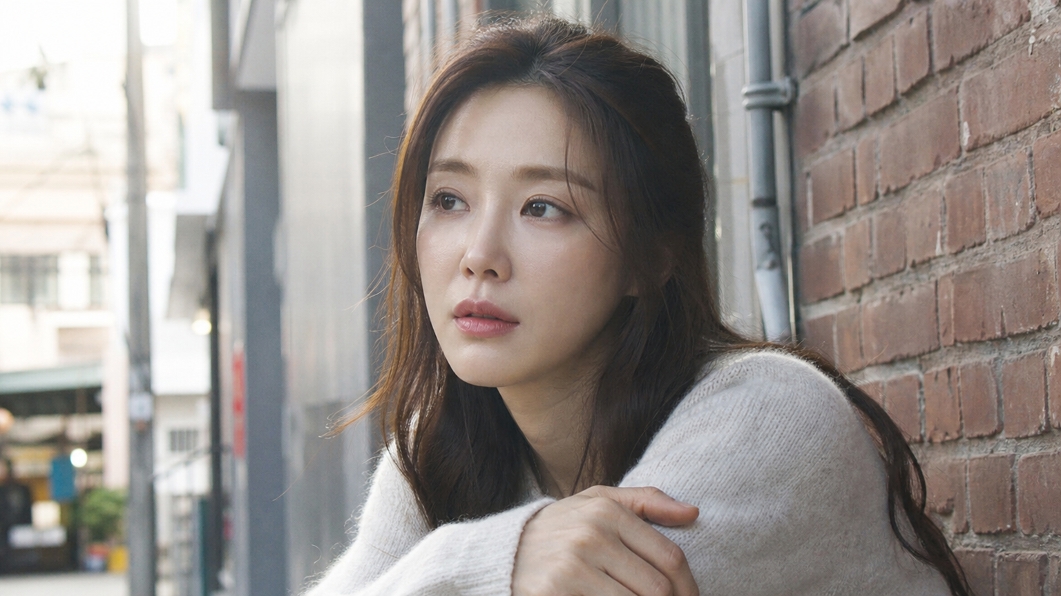 현대적인 도시 배경에서 캐주얼한 옷차림으로 사색에 잠긴 홍이설