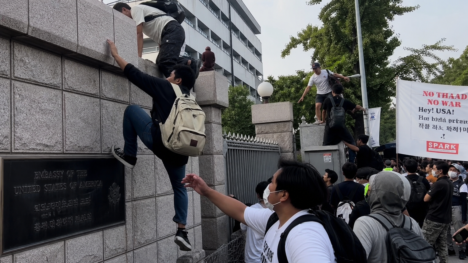 격렬한 시위 중 미국 대사관 벽을 넘는 시위자들