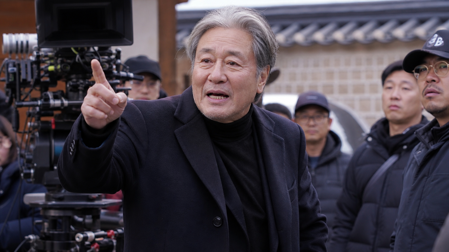 70대 배우가 영화 세트장에서 활기차게 서 있는 모습