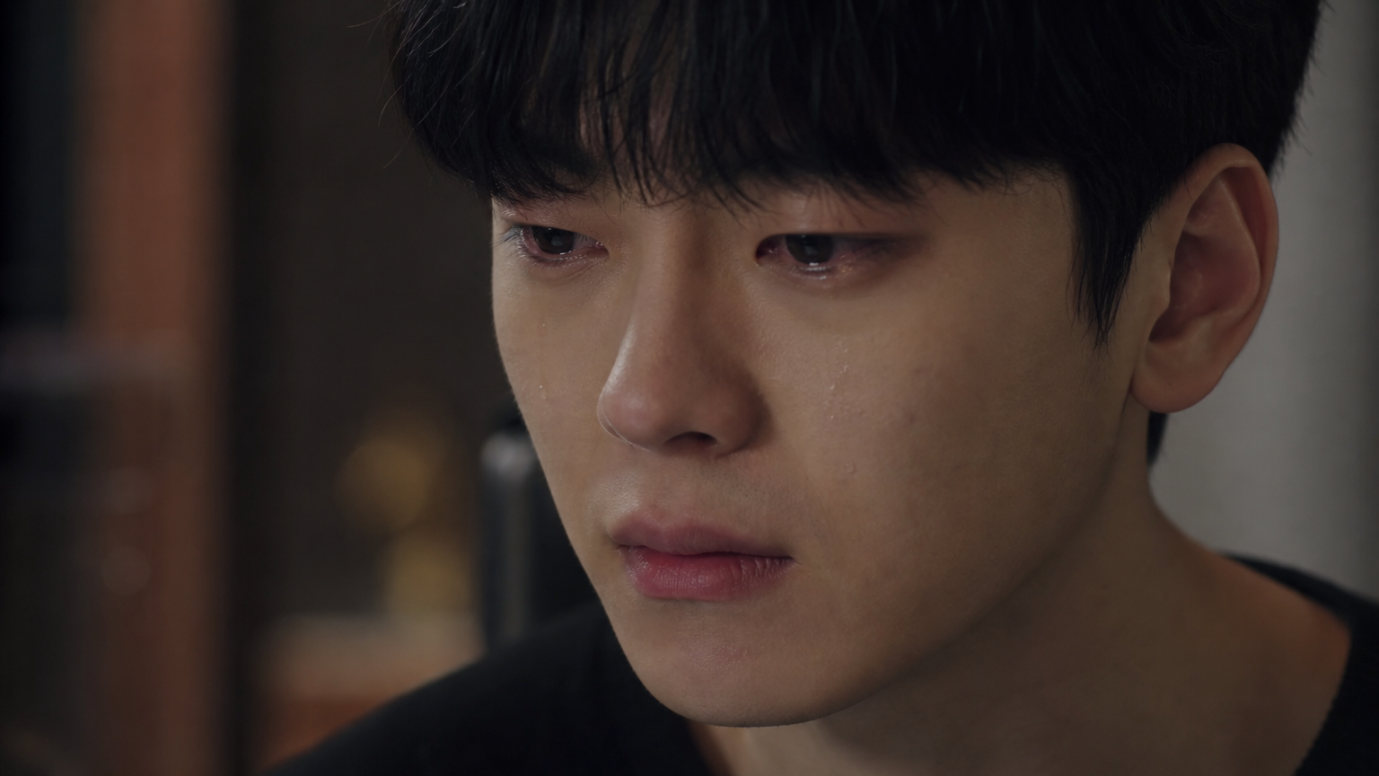 과거의 아픈 기억을 떠올리며 깊이 생각에 잠긴 젊은 사람의 표정