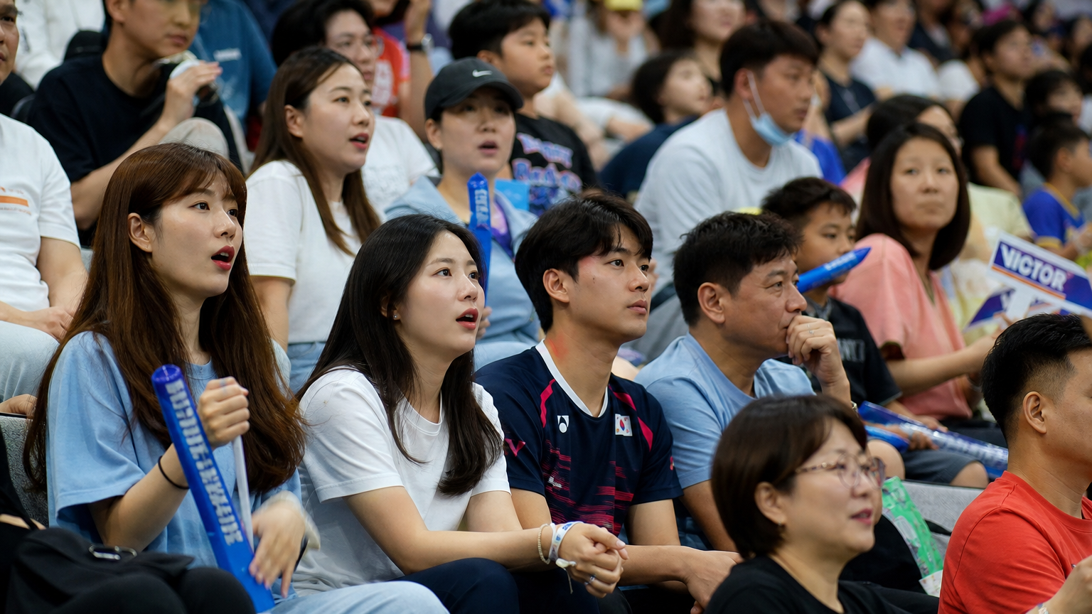 배드민턴 경기를 관람하는 다양한 연령층의 한국인 관중들