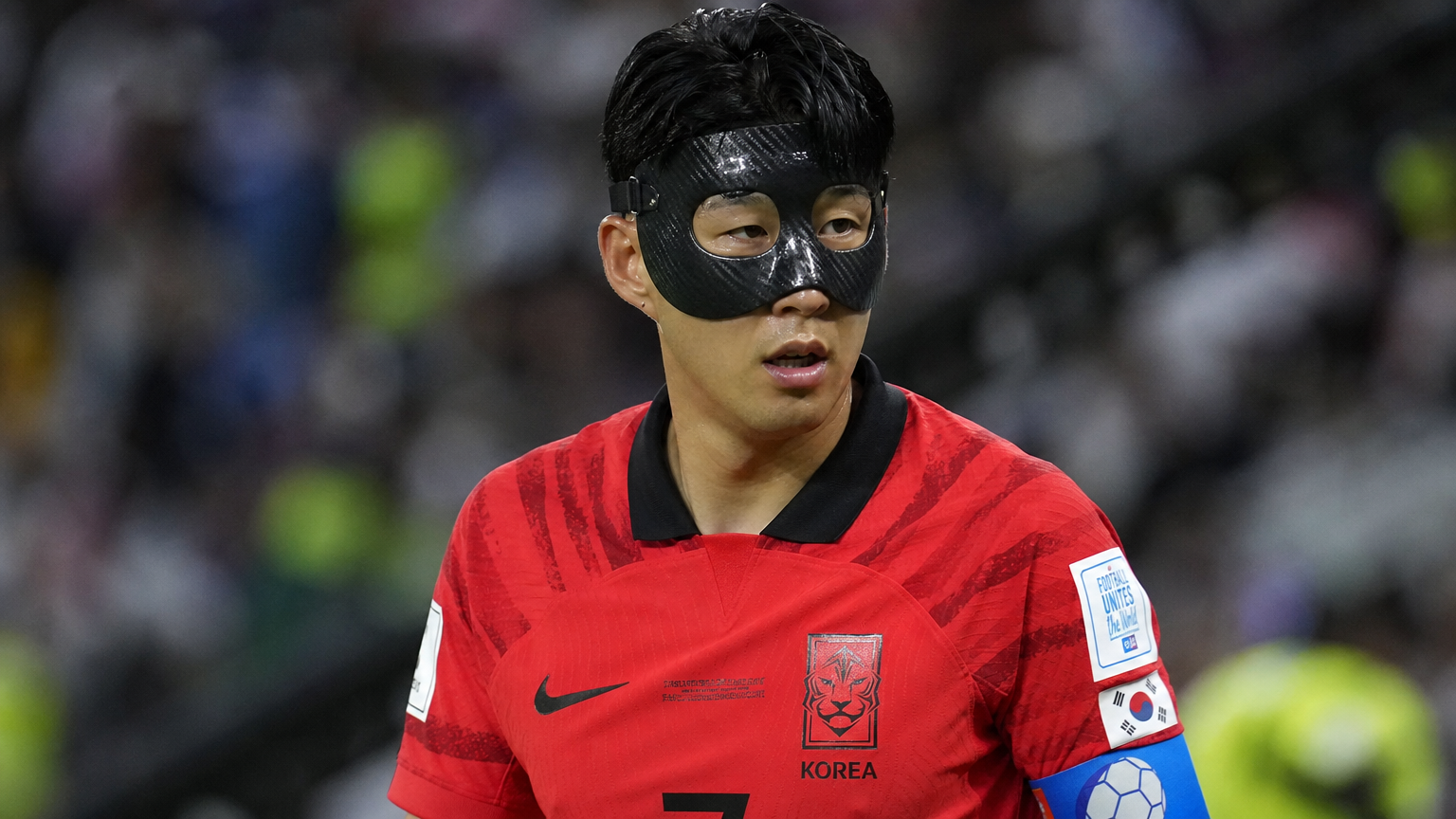 카타르 월드컵 경기장에서 검은 마스크를 쓴 축구 선수의 모습