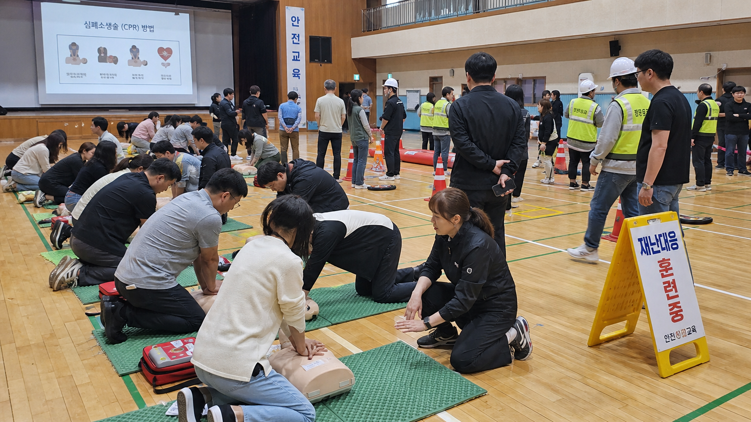 학교 체육관에서 심폐소생술 연습 및 비상 대응 훈련 등 다양한 안전 교육 활동에 참여하는 모습