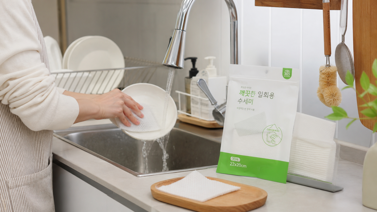 깔끔한 주방에서 일회용 수세미로 설거지를 하는 모습