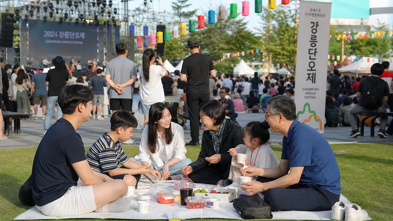 남대천에서 열리는 강릉 단오제의 다양한 전통 공연과 현대적 놀이를 즐기는 가족들