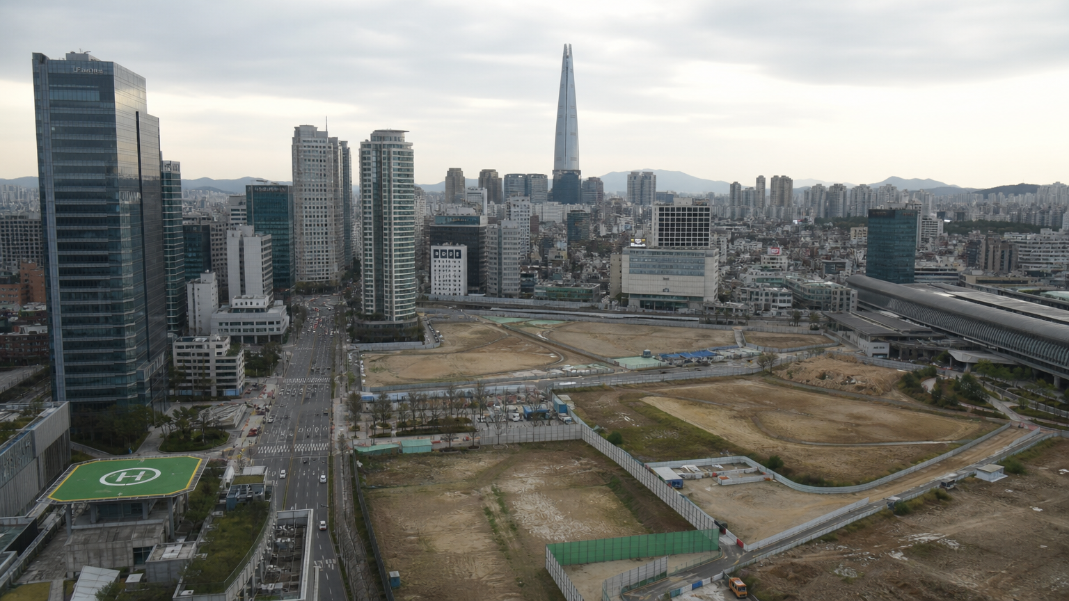 현대 한국 도시 풍경 속 상징적으로 비어있는 토지 구획과 고층 건물들 사이에 놓인 미해결된 역사 문제