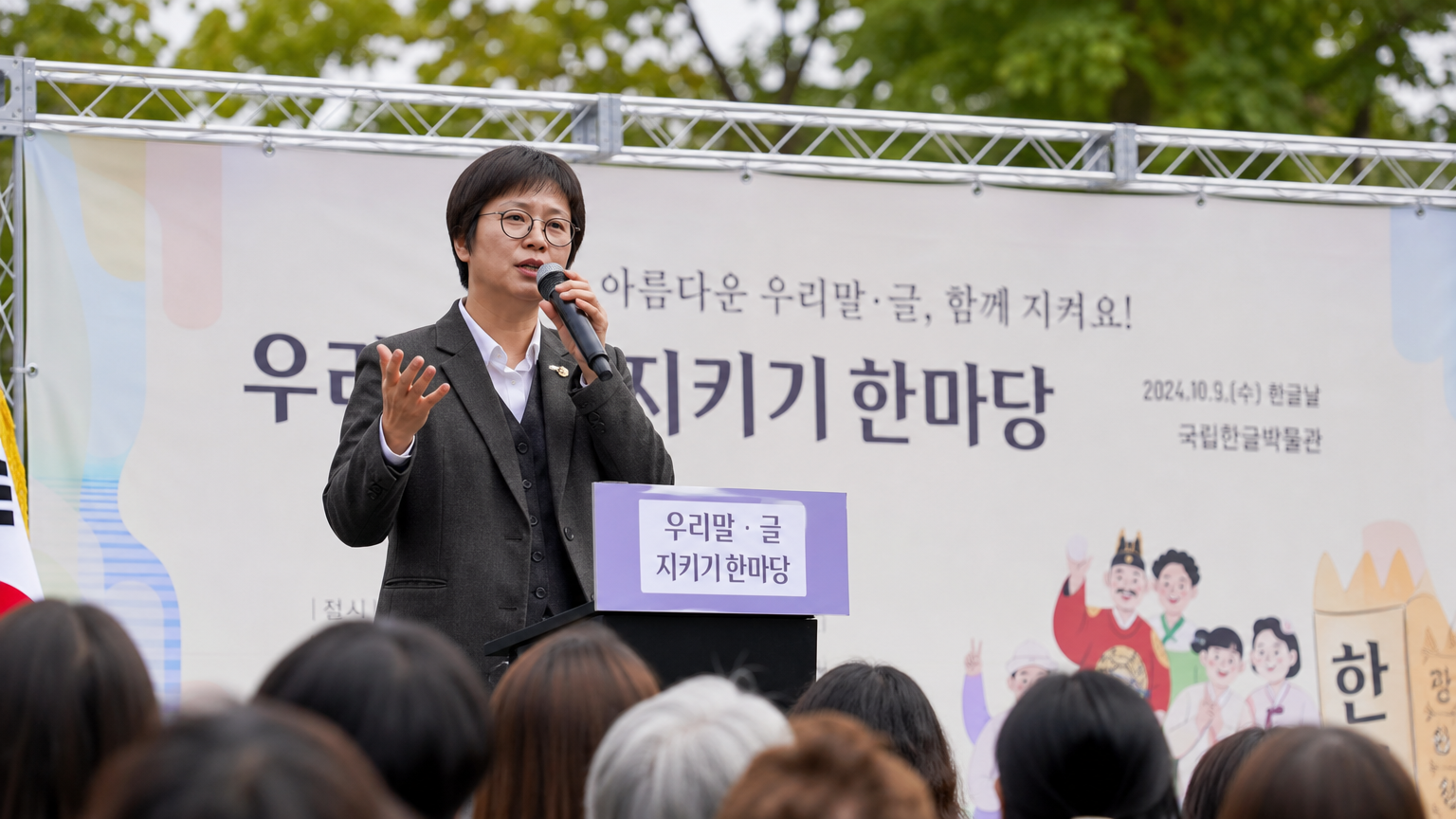야외 문화 행사에서 한국어 보존 캠페인을 이끄는 언어학자의 헌신적인 모습