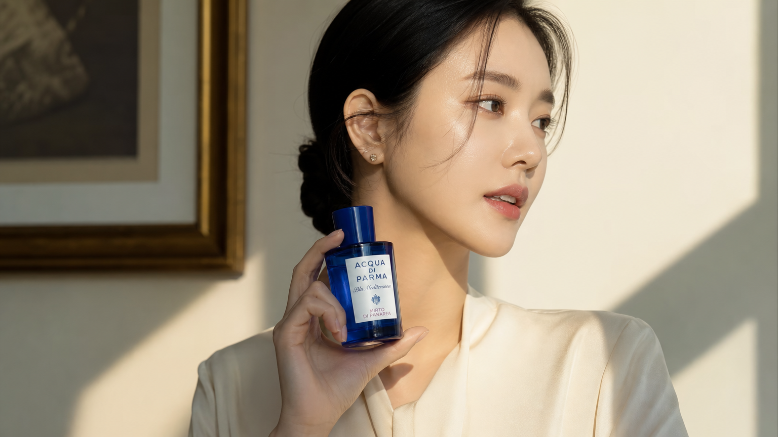 세련된 여성이 햇빛 아래 아쿠아디파르마 향수를 들고 있는 모습
