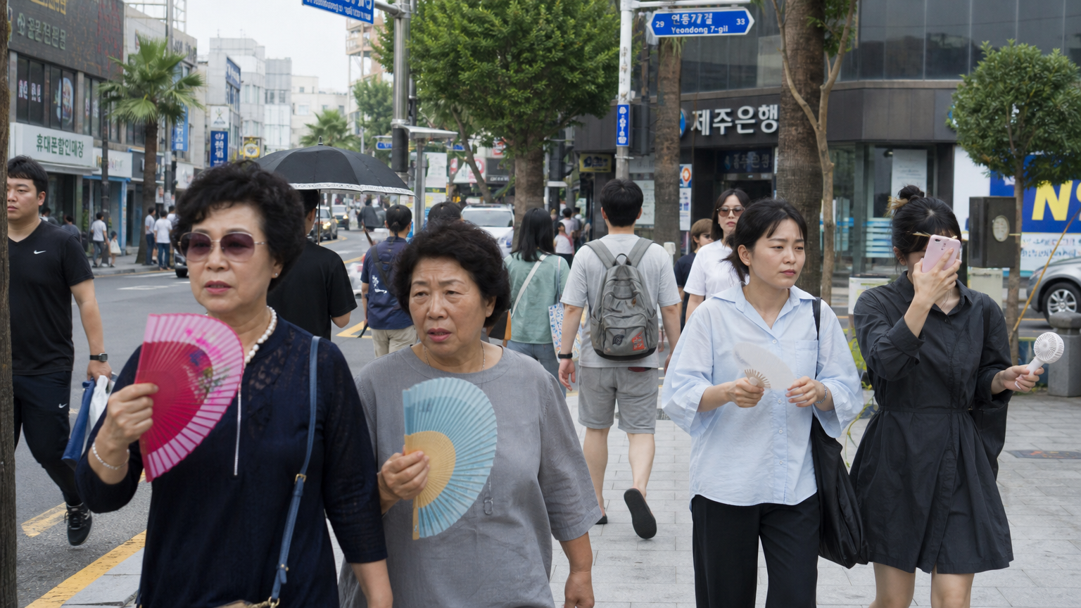 높은 습도 속에서 부채질하며 걷는 도시 사람들