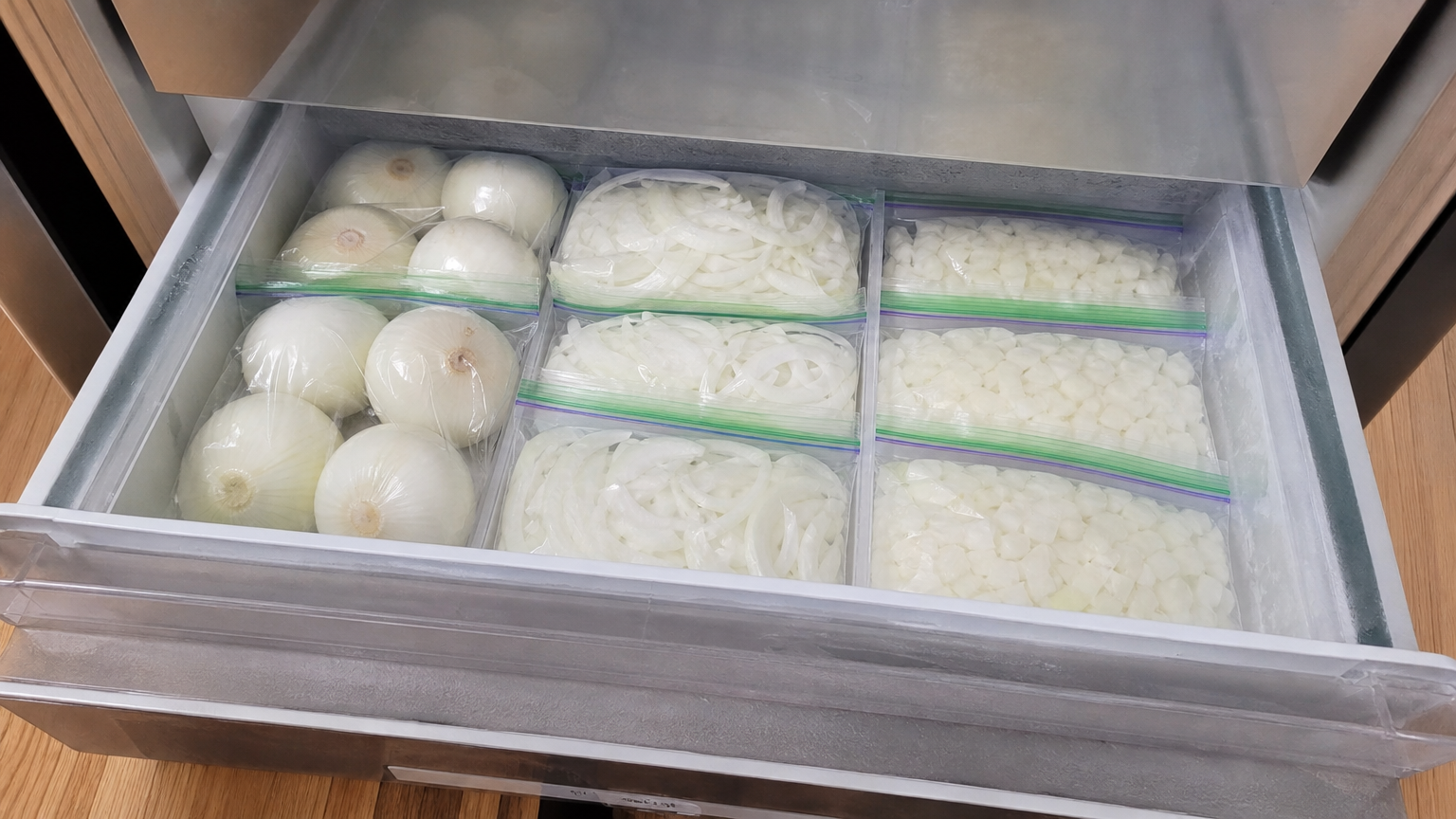 지퍼백에 담아 냉동실 서랍에 깔끔하게 보관된 깐 양파와 다진 양파