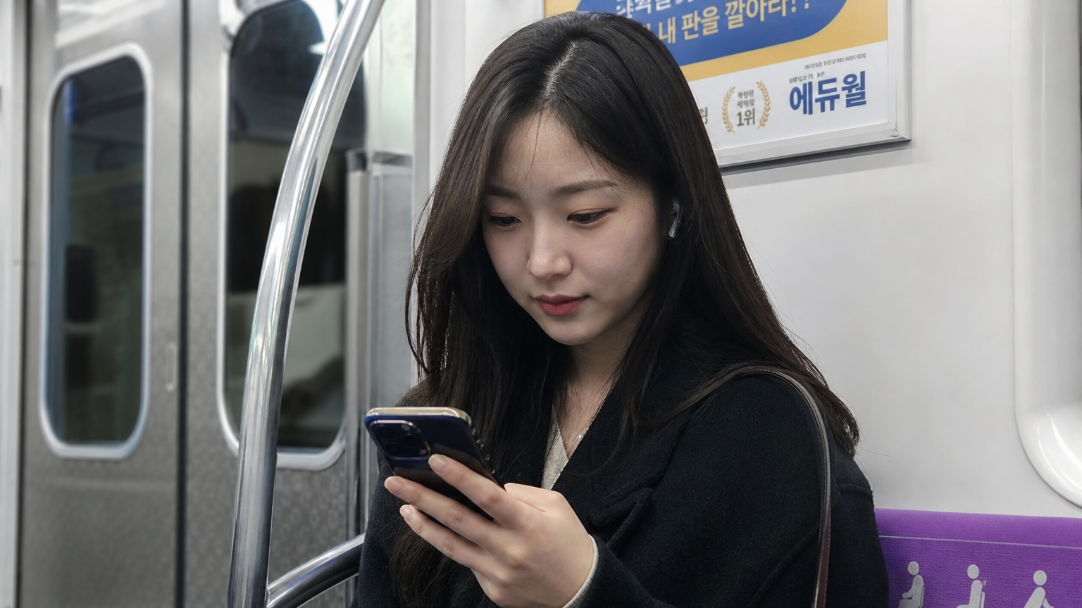 서울 지하철에서 스마트폰으로 웹툰을 읽는 젊은 여성