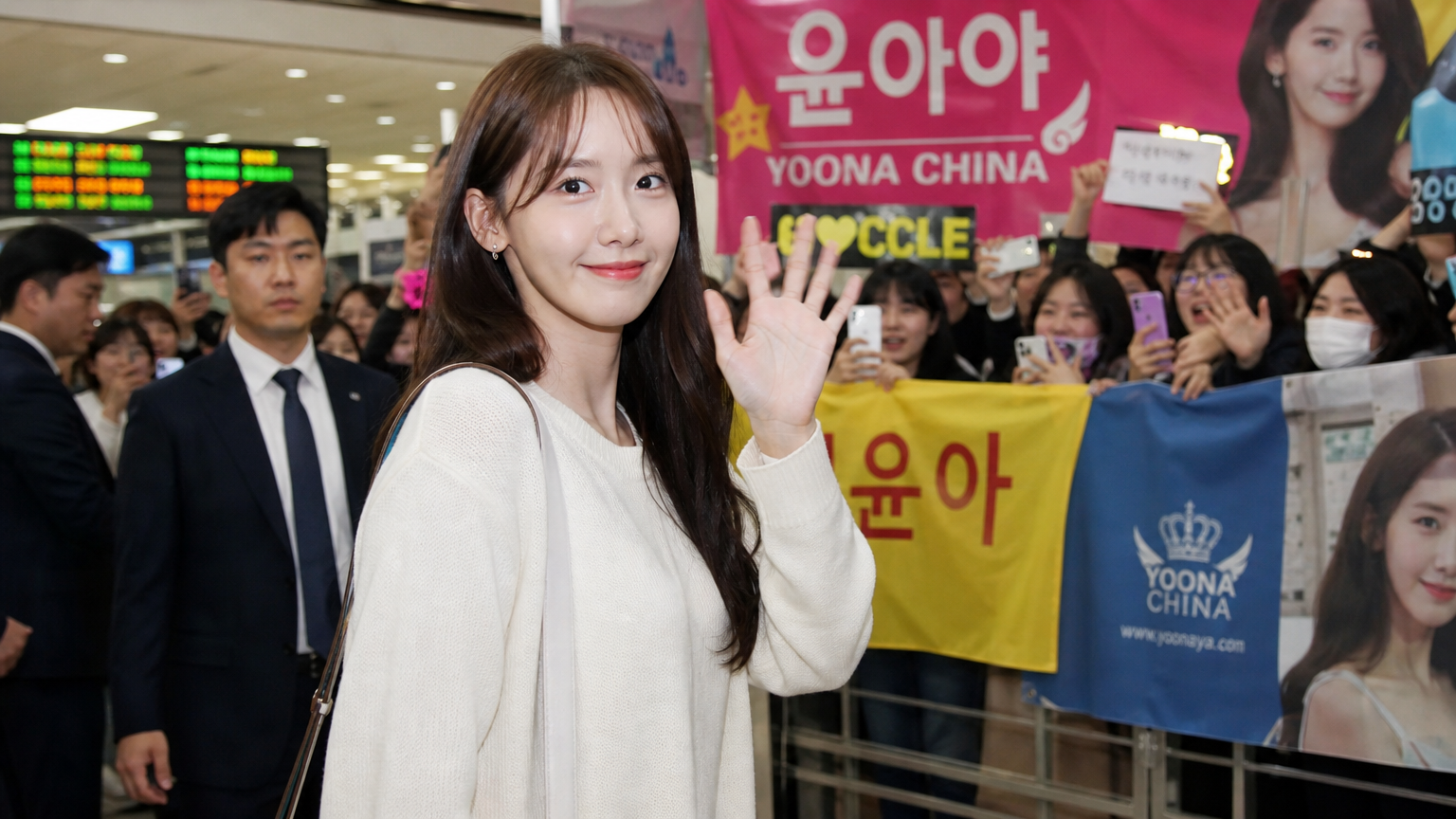 공항 도착 게이트에서 국제 팬들에게 손을 흔드는 한국 여배우