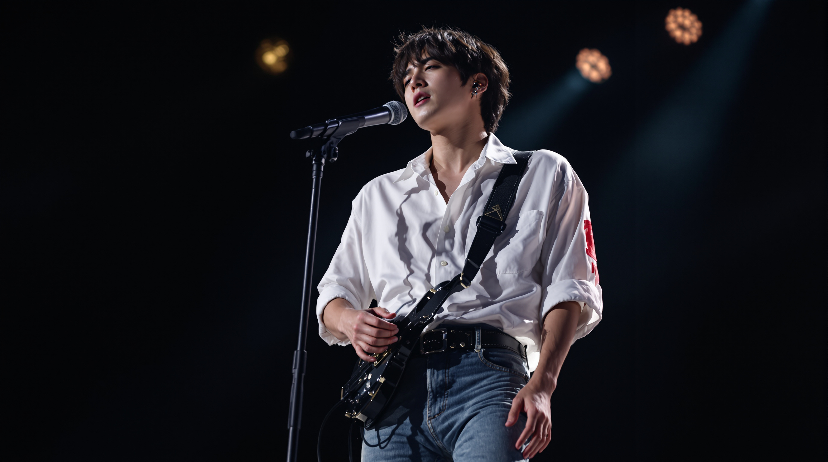 심플한 흰 셔츠와 청바지를 입고 무대에서 공연 중인 이승윤